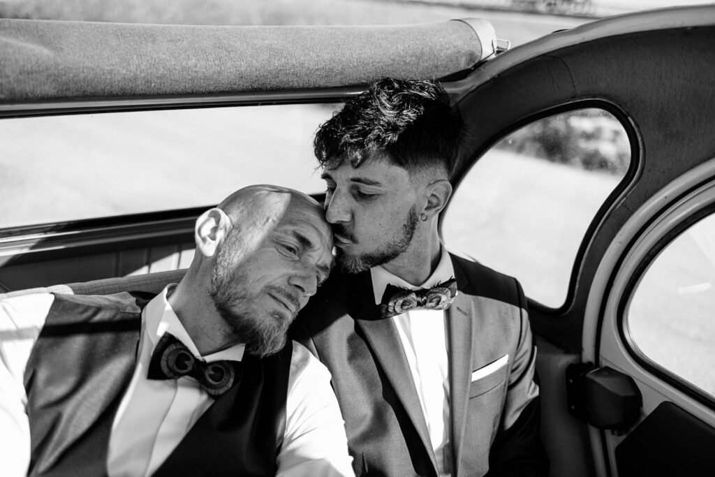 un homme qui embrasse son mari sur le front dans la 2cv lors d'un mariage gay à la rochelle par Once Upon a Day duo photo et video de mariage en Alsace