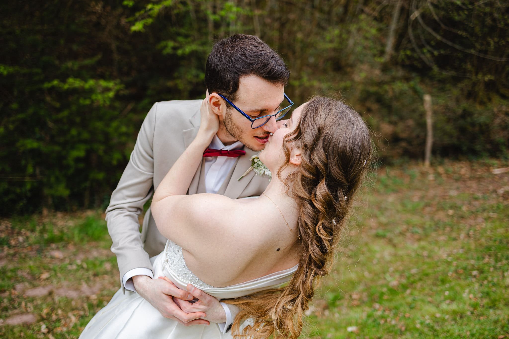 Alexis embrasse Margaux en la renversant tendrement en arrière, lors de leur séance couple de mariage. Mariage en Alsace
